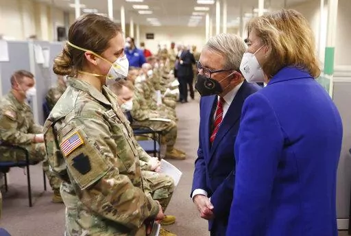 Ohio Gov. Mike DeWine, center, and his wife Fran, right, talk with specialist Emily Milosevic as they tour the Defense Supply Center Columbus in Columbus, Ohio, as members of the Ohio Army National Guard prepare to deploy to aid Ohio hospitals during the current surge in COVID-19 hospitalizations Jan. 6, 2022. Up to 40,000 Army National Guard soldiers across the country - or about 13% of the force — have not yet gotten the mandated COVID-19 vaccine, and as the deadline for shots looms, at leas