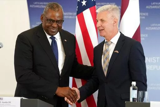 U.S. Secretary of Defense Lloyd Austin, left, and Latvian Minister of Defence Artis Pabriks shake hands during the press conference in Riga, Latvia, Wednesday, Aug. 10, 2022. (AP Photo/Roman Koksarov)