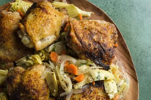 This image released by Milk Street shows a recipe for chicken with artichokes and white wine. (Milk Street via AP)
