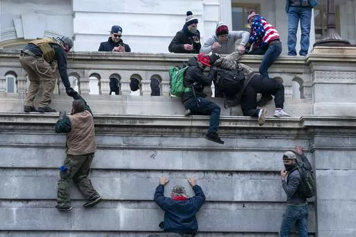 Rioters loyal to President Donald Trump climb the west wall of the the U.S. Capitol, Jan. 6, 2021, in Washington. (AP Photo/Jose Luis Magana, File)