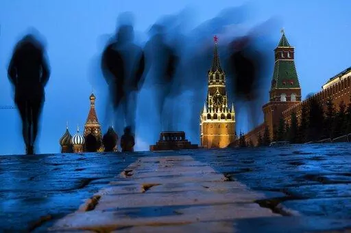 People walk through Red Square after sunset in Moscow, Russia, on March 3, 2019, with the St. Basil's left, and the Spasskaya Tower, second right, in the background. Russian technology workers are fleeing the country by the tens of thousands as the economy goes into a tailspin under pressure from international sanctions. For some countries, Russia’s loss is being seen as their potential gain and an opportunity to bring fresh expertise to their own high-tech industries. (AP Photo/Alexander Zeml