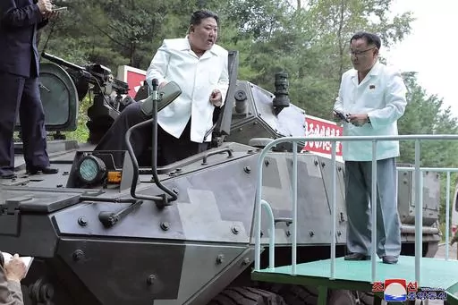 In this undated photo provided on Monday, Aug. 14, 2023, by the North Korean government, North Korean leader Kim Jong Un, center, rides on an armored vehicle during his Aug. 11-12 visit to a military factory in North Korea. Independent journalists were not given access to cover the event depicted in this image distributed by the North Korean government. The content of this image is as provided and cannot be independently verified. Korean language watermark on image as provided by source reads: "
