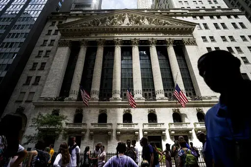 Pedestrians walk past the New York Stock Exchange on Friday, July 8, 2022, in New York. Stocks wavered between gains and losses in morning trading on Wall Street Monday, Aug. 1, 2022 as investors face another busy week of corporate earnings reports and economic updates. (AP Photo/John Minchillo, File)