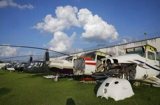 Planes and helicopters seized for allegedly being connected to illegal gold mining activity sit in the backyard of the Federal Police headquarters in Boa Vista, Roraima state, Brazil, Wednesday, Nov. 3, 2021. Generally, the illegal aircraft owners are local elites who launder their money in Boa Vista hotels, restaurants, gyms and gasoline stations, according to the police, which declined to disclose names.(AP Photo/Andre Penner)