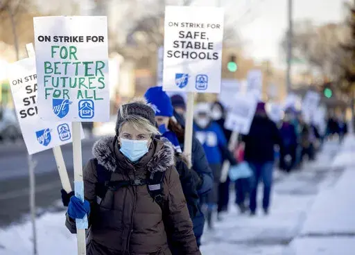 Minneapolis teachers and supporters picket at 34th street and Chicago Avenue South in Minneapolis, on Tuesday, March 8, 2022.   Teachers walked off the job on Tuesday in a dispute over wages, class sizes and mental health support for students coping with two years of the coronavirus pandemic, at least temporarily pausing classes for about 29,000 students in one of Minnesota's largest school districts. (Elizabeth Flores/Star Tribune via AP)