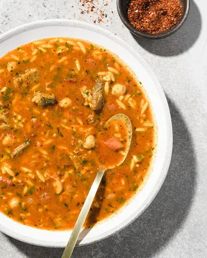 This image released by Milk Street shows a recipe for harissa-spiced beef and pasta soup. (Milk Street via AP)