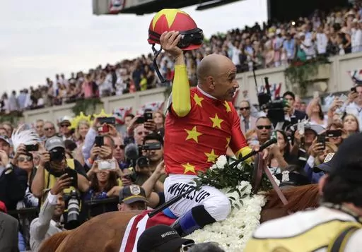 Jockey Mike Smith tips his helmet to the crowd as he rides Justify to the winner's circle after winning the 150th running of the Belmont Stakes horse race and Triple Crown on June 9, 2018, in Elmont, N.Y. Earlier in 2023, horse racing was rocked by the deaths less than six weeks apart of two young jockeys, 23-year-old Avery Whisman and 29-year-old Alex Canchari, each of whom killed himself. A friend of Whisman's, Triple Crown-winning rider Mike Smith has over three decades seen similar tragedies