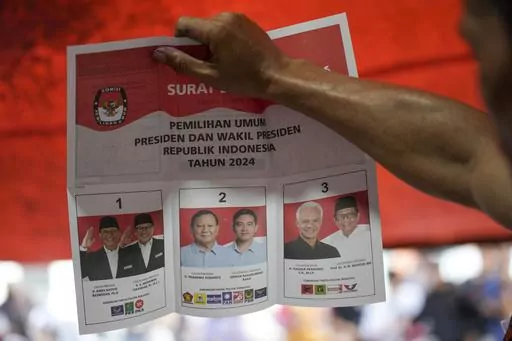 An electoral worker holds up a ballot showing a vote for presidential candidate Prabowo Subianto and his running mate Gibran Rakabuming Raka, the eldest son of Indonesian President Joko Widodo, during the vote counting at a polling station following the election in Jakarta, Indonesia, Wednesday, Feb. 14, 2024. The camps of the two presidential candidates who appear to have lost in Indonesia's election last month said Thursday they plan to challenge the results in the Constitutional Court with al