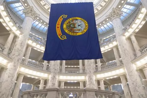 The Idaho state flag hangs in the State Capitol in Boise, Idaho, Jan. 9, 2023. The Idaho Senate is expected to take a final vote on Monday, March 18, 2024, on a bill that would prohibit transgender and nonbinary Idahoans enrolled in Medicaid, or state employees enrolled in the state's insurance plan, from obtaining gender-affirming care. (AP Photo/Kyle Green, File)