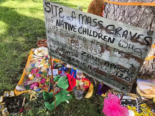 A makeshift memorial for the dozens of Indigenous children who died more than a century ago while attending a boarding school that was once located nearby is displayed under a tree at a public park in Albuquerque, N.M., on  July 1, 2021. The U.S. Interior Department is expected to release a report Wednesday, May 11, 2022, that it says will begin to uncover the truth about the federal government's past oversight of Native American boarding schools. (AP Photo/Susan Montoya Bryan, File)