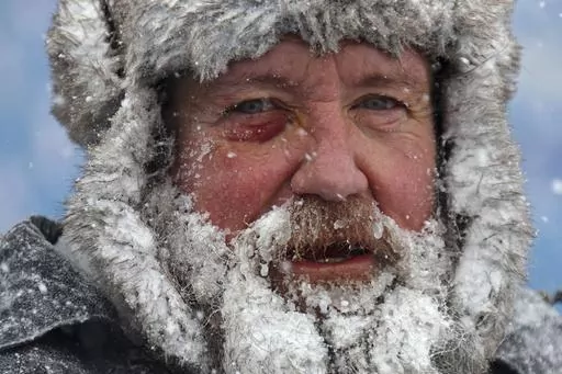 A worker pauses while removing snow from Highmark Stadium in Orchard Park, N.Y., Jan. 14, 2024. While the U.S. is shivering through bone-chilling cold, most of the rest of world is feeling unusually warm weather. Scientists Tuesday, Jan. 16, say that fits with what climate change is doing to Earth. (AP Photo/ Jeffrey T. Barnes, File)