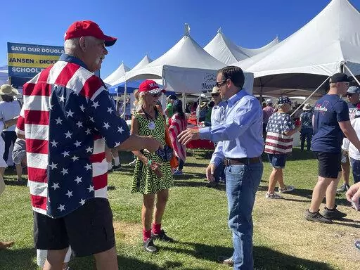 Republican Nevada Senate candidate Adam Laxalt, right, takes pictures with supporters at the seventh annual Basque Fry at the Corley Ranch on Saturday, Aug. 13, 2022, outside Gardnerville, Nev. (AP Photo/Gabe Stern)