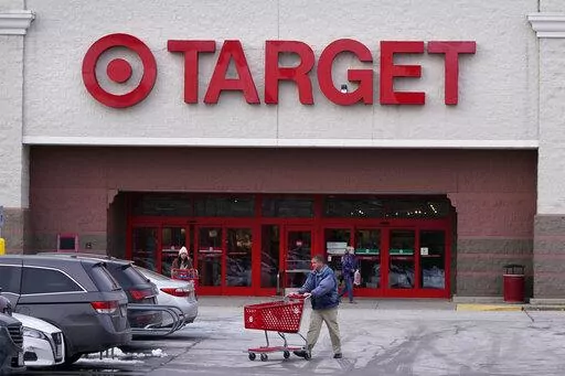 A shopper wheels his shopping cart through the parking lot after making a purchase at the Target store, Monday, Feb. 27, 2023, in Salem, N.H. Target reported on Tuesday, Feb. 28, a 43% drop in profits and a slight uptick in sales for the holiday quarter, reflecting the discounter's ongoing challenges of cautious consumer spending and its own higher costs. (AP Photo/Charles Krupa)