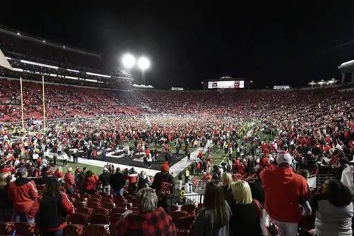 Fans flood the field following Louisville's victory over Notre Dame in an NCAA college football game in Louisville, Ky., Saturday, Oct. 7, 2023. (AP Photo/Timothy D. Easley)