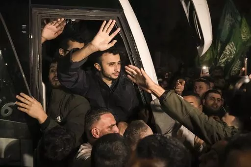 Men wave after being released from prison by Israel, Thursday, Nov. 30, 2023, in the West Bank town of Ramallah. (AP Photo/Nasser Nasser, File)