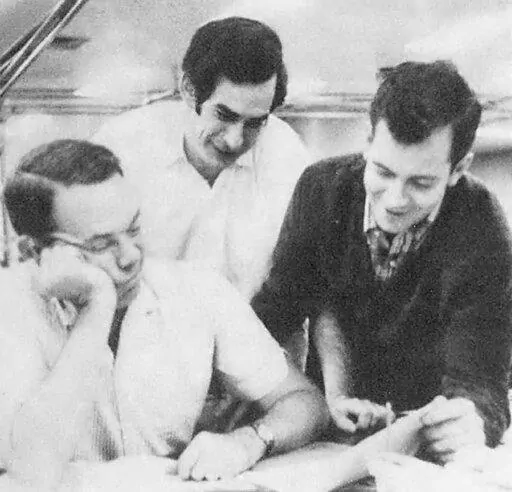 In this 1967 photo Associated Press staffers, from left, supervisor Harris Jackson, John Vinocur and Pat O’Keefe work on AP's international desk in New York. Vinocur, a much-respected foreign correspondent for The New York Times and The Associated Press and later executive editor and columnist at the International Herald Tribune in Paris, has died. His son told The New York Times that Vinocur died in Amsterdam on Sunday, Feb. 6, 2022, from complications from sepsis. He was 81.   (AP Photo)