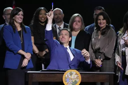 Florida Gov. Ron DeSantis throws a marker into the audience after signing various bills during a bill signing ceremony at the Coastal Community Church at Lighthouse Point, Tuesday, May 16, 2023, in Lighthouse Point, Fla. (AP Photo/Wilfredo Lee)