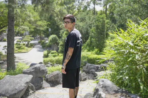 Joker Chan poses for photographs after an interview, in Hong Kong, on June 28, 2024. Chan, 30, was sentenced in 2022 for posts containing slogans like “Liberate Hong Kong, revolution of our times,” which were popularly chanted during massive anti-government protests in the city in 2019. Authorities said such slogans could imply separating Hong Kong from China — a red line for Beijing. (AP Photo/Billy H.C. Kwok)