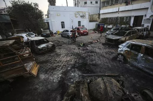 Palestinian men look over the site of a deadly explosion at al-Ahli Hospital in Gaza City, Wednesday, Oct. 18, 2023. (AP Photo/Abed Khaled)
