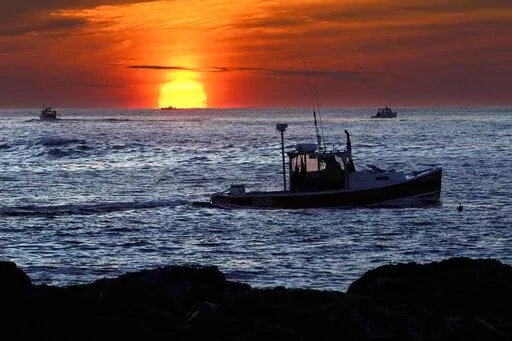 Lobster fishermen work at sunrise, Thursday, Sept. 8, 2022, off Kennebunkport, Maine. The waters off New England logged the second-warmest year in their recorded history in 2022, according to researchers. The Gulf of Maine, a body of water about the size of Indiana that touches Maine, New Hampshire, Massachusetts and Canada, is warming faster than the vast majority of the world's oceans. Scientists with Gulf of Maine Research Institute say 2022 fell short of setting a new high mark for hottest y