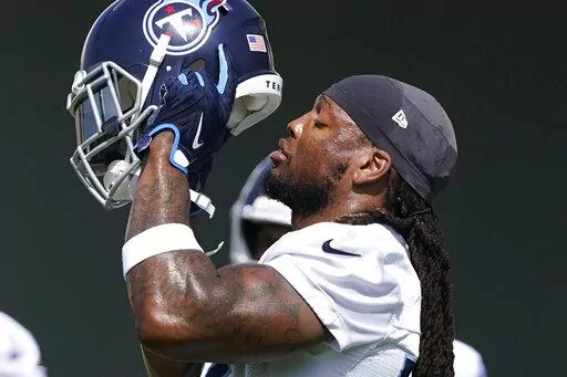 Tennessee Titans running back Derrick Henry puts on his helmet at the NFL football team's practice facility, Wednesday, June 15, 2022, in Nashville, Tenn.  (AP Photo/Mark Humphrey)