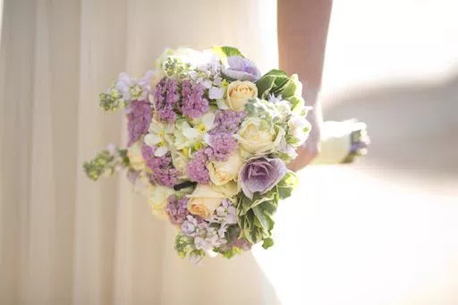 A bride holds a bouquet during her wedding in Ein Hemed, Israel on Dec. 14, 2017. The Marriage Pact is an annual matching ritual that has become a popular staple on nearly 90 college campuses around the country. About 500,000 students have done the pact since it first rolled out at Stanford University in 2017. (AP Photo/Ariel Schalit, File)