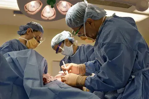 Surgeons perform a bilateral mastectomy on a transgender patient at a hospital in Boston on Friday, July 15, 2016. On Wednesday, July 3, 2024, a U.S. federal district court judge temporarily halted parts of a nondiscrimination rule that would have kept insurers and medical professionals from denying hormone therapy, gender transition surgeries and similar medical care for transgender people. (Christine Hochkeppel/Worcester Telegram & Gazette via AP, File)