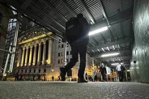 People walk under a sidewalk shed near the New York Stock Exchange on Oct. 30, 2024. (AP Photo/Peter Morgan, File)