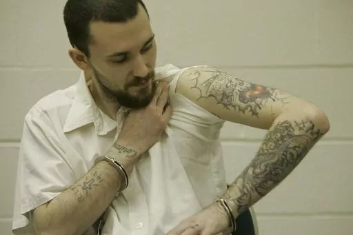 Inmate Michael Tisius, sentenced to death in the killing of two jail officers, shows his tattoos during an interview at Potosi Correctional Center, Missouri's maximum security prison where condemned men live in the general prison population in Mineral Point, Mo., on Jan. 11, 2007. A federal judge on Wednesday, May 31, 2023, halted next week's scheduled execution of Tisius, a man convicted of killing two Missouri jailers, amid questions about the literacy of a juror in the case. (AP Photo/Jeff Ro