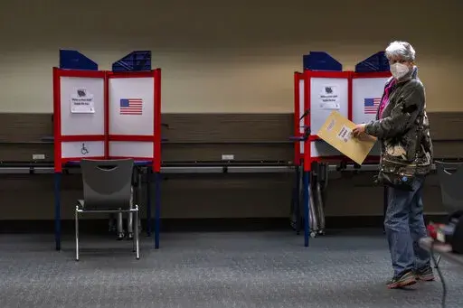 Kathie Hoekstra arrives to vote in Alexandria, Va., Monday, Sept. 26, 2022. In-person voting for the midterm elections has started in Minnesota, South Dakota, Virginia and Wyoming, in a landscape that has changed since the pandemic drove a shift to mail balloting in the 2020 presidential contest. (AP Photo/Andrew Harnik)