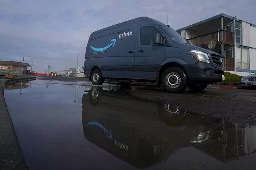 An Amazon Prime truck drives in Pacifica, Calif., on Dec. 15, 2020. Amazon has begun mass layoffs in its corporate ranks, becoming the latest tech company to trim its workforce amid rising fears about the wider economic environment. (AP Photo/Jeff Chiu, File)