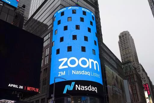 This April 18, 2019, file photo shows a sign for Zoom Video Communications ahead of the company's Nasdaq IPO in New York. The video-conferencing service is cutting about 1,300 jobs, or approximately 15% of its workforce. CEO Eric Yuan said in a blog post Tuesday, Feb. 7, 2023, that the company ramped up staffing during the COVID-19 pandemic, when businesses became increasingly reliant on its service as people worked from home. Yuan said Zoom grew three times in size within 24 months to manage de