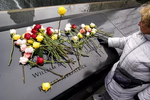 Mourners place flowers over the names of the victims of the 1993 World Trade Center bombing during a ceremony at the 9/11 Memorial, Sunday, Feb. 26, 2023, in New York. (AP Photo/John Minchillo)