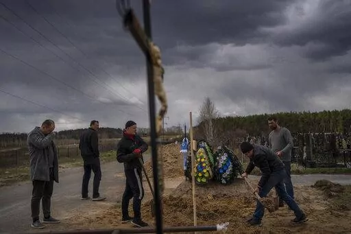 Anatoliy Morykin, 45, left, mourns the death of his mother Valentyna Morykina, 82, who died in a retirement home due to poor living conditions during the Russian invasion in Bucha, on the outskirts of Kyiv, Ukraine, Tuesday, April 12, 2022. (AP Photo/Rodrigo Abd)