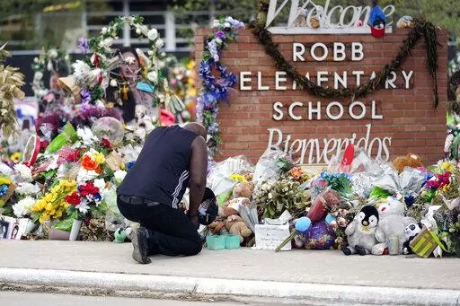 Reggie Daniels pays his respects a memorial at Robb Elementary School on June 9, 2022, in Uvalde, Texas. Nearly 400 law enforcement officials rushed to the mass shooting that left 21 people dead at the elementary school but “systemic failures” created a chaotic scene that lasted more than an hour before the gunman was finally confronted and killed, according to a report from investigators released Sunday, July 17, 2022. (AP Photo/Eric Gay, File)