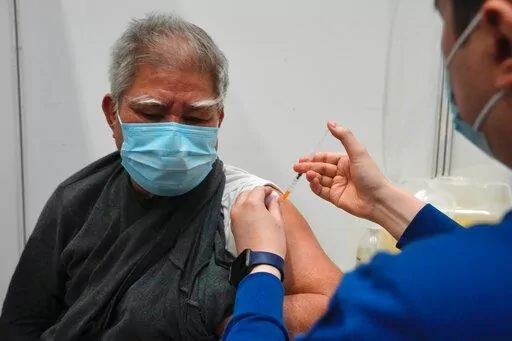 Hui Ngai-seng, 75, receives his first dose of China's Sinovac COVID-19 coronavirus vaccine at a community vaccination center in Hong Kong, Friday, Feb. 25, 2022. (AP Photo/Kin Cheung)