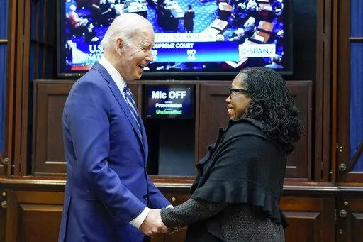 President Joe Biden holds hands with Supreme Court nominee Judge Ketanji Brown Jackson as they watch the Senate vote on her confirmation from the Roosevelt Room of the White House in Washington, Thursday, April 7, 2022. (AP Photo/Susan Walsh)