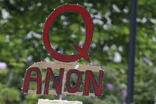 A person carries a sign supporting QAnon during a protest rally in Olympia, Wash., on May 14, 2020. The QAnon conspiracy theory has been linked to acts of real-world violence, including last year's riot at the U.S. Capitol. In June 2021, a federal intelligence report warned that QAnon adherents could target Democrats and other political opponents for more violence. (AP Photo/Ted S. Warren, File)