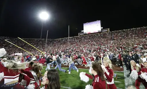 Oklahoma students and fans rush the field after Oklahoma defeated Alabama during a NCAA college football game Saturday, Nov. 23, 2024, in Norman, Okla. (AP Photo/Alonzo Adams)