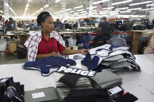 Laurette Eugene assembles a body armor vest at the Point Blank Body Armor factory in Pompano Beach, Fla., Sept. 19, 2014. When a shooter attacked a supermarket in Buffalo, New York,May 14, 2022, its security guard tried to stop him. At least one of the guard's shots hit the gunman, but it didn’t stop the deadly rampage because the gunman was wearing body armor. (AP Photo/J Pat Carter, File)