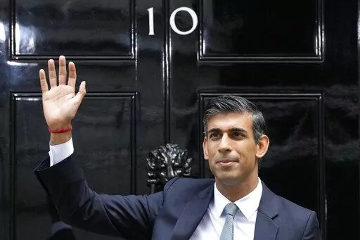 New British Prime Minister Rishi Sunak waves after arriving at Downing Street in London, Tuesday, Oct. 25, 2022, after returning from Buckingham Palace where he was formally appointed to the post by Britain's King Charles III. (AP Photo/Frank Augstein, File)