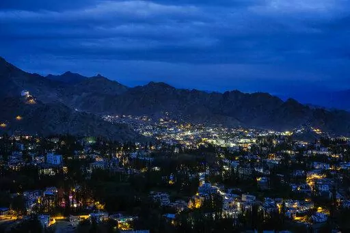 Lights shine in Leh in the cold desert region of Ladakh, India, Tuesday, Sept. 20, 2022. Konchok Dorjey gave up his pastoral life in search of a better future for his family. He sold off his animals and migrated to an urban settlement in the outskirts of Leh. (AP Photo/Mukhtar Khan)