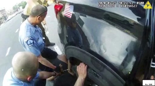In this image from police body camera video shown as evidence in court, paramedics arrive as Minneapolis police officers, including Derick Chauvin, second from left, and J. Alexander Kueng restrain George Floyd in Minneapolis, on May 25, 2020. Former police officers Tou Thao, Kueng and Thomas Lane are on trial in federal court accused of violating Floyd's civil rights as fellow Officer Derek Chauvin killed him. (Minneapolis Police Department via AP, File)