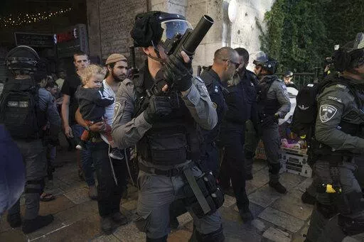 Israeli security forces escort a group of Jews outside Damascus Gate, in Jerusalem's Old City, Wednesday, April 20, 2022. Police prevented hundreds of ultra-nationalist Israelis from marching around predominantly Palestinian areas of Jerusalem's Old City. The event planned for Wednesday was similar to one that served as one of the triggers of last year's Israel-Gaza war. (AP Photo/Mahmoud Illean)