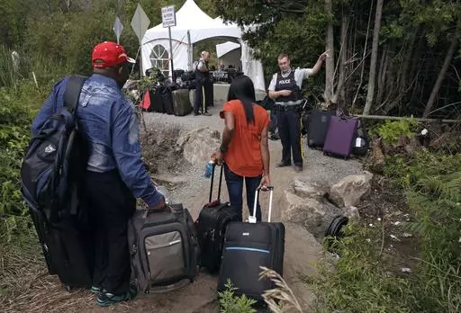 A Royal Canadian Mounted Police officer informs a migrant couple of the location of a legal border station, shortly before they illegally crossed from Champlain, N.Y., to Saint-Bernard-de-Lacolle, Quebec, using Roxham Road. Canada’s government is reimposing some visa requirements on Mexican nationals visiting Canada, an official familiar with the matter told The Associated Press on Wednesday, Feb. 28, 2024. Quebec’s premier has been urging the federal government to slow the influx of refugee