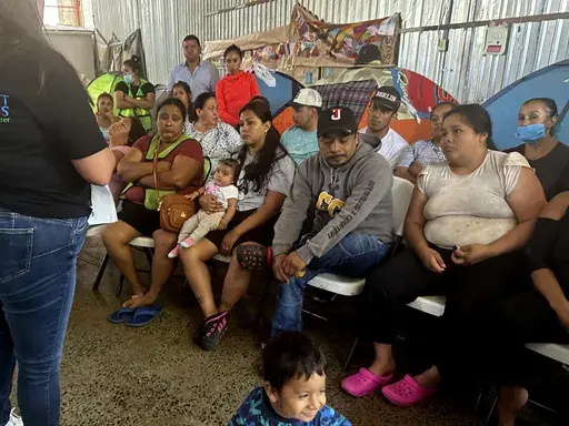 Melissa Shepard, left, directing attorney of Immigrant Defenders Law Center, explains the Biden administration's new asylum restrictions to migrants at the Juventud 2000 shelter in Tijuana, Mexico, on Monday, June 17, 2024. (AP Photo/Elliot Spagat)