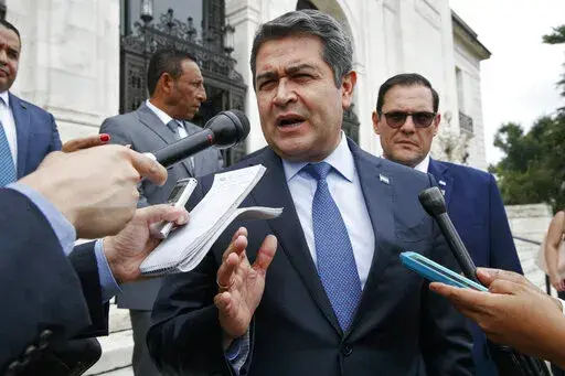 Honduran President Juan Orlando Hernandez answers questions from the Associated Press, Tuesday, Aug. 13, 2019, as he leaves a meeting at the Organization of American States, in Washington. The U.S. government is formally requesting on Monday, Feb. 14, 2022, the arrest and extradition of ex-president Hernandez. (AP Photo/Jacquelyn Martin,File)