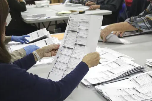 An election worker examines a ballot at the Clackamas County Elections office on Thursday, May 19, 2022, in Oregon City, Ore. On Tuesday, July 19, 2022, elections officials from across the country meeting under heightened security in swing state Wisconsin were urged to prepare for supply chain issues that could lead to shortages in paper used for everything from ballots to “I voted” stickers for years to come. (AP Photo/Gillian Flaccus,File)