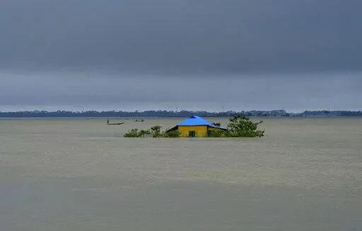 A house stands surrounded by floodwaters in Sylhet, Bangladesh, Monday, June 20, 2022. Early and strong monsoon rains have brought heavy flooding to northeastern India and Bangladesh, killing dozens of people, forcing hundreds of thousands from their homes and cutting millions off from crucial supplies. (AP Photo/Mahmud Hossain Opu)