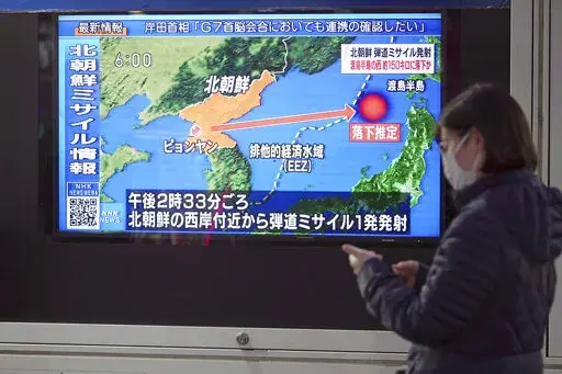 A woman walks along a sidewalk past a TV displaying a news program on North Korea's missile launch Thursday, March 24, 2022, in Tokyo. North Korea has fired a suspected long-range missile toward the sea in what would be its first such test since 2017, raising the ante in a pressure campaign aimed at forcing the United States and other rivals to accept it as a nuclear power and remove crippling sanctions. (AP Photo/Eugene Hoshiko)
